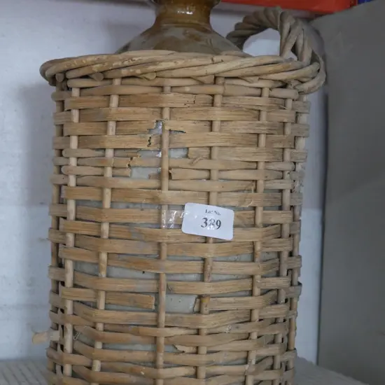 Stone jar in wicker basket A/F