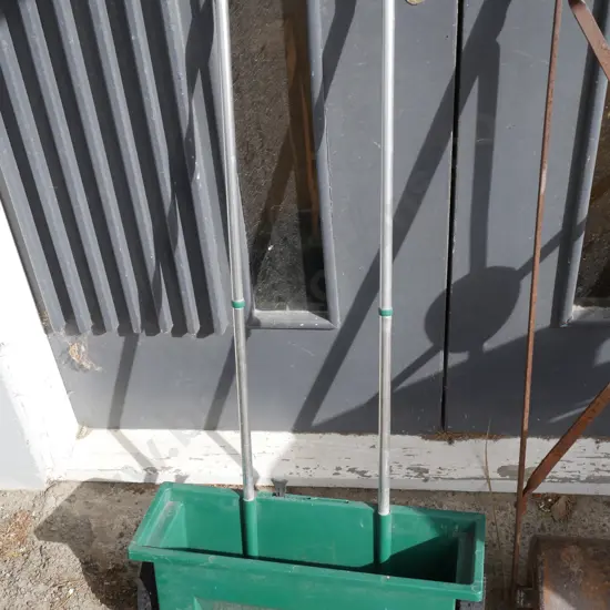 Push along lawn spreader