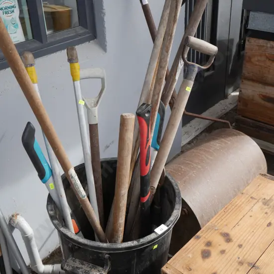 Assorted garden tools in bin
