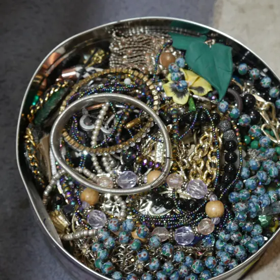 Tin of costume jewellery