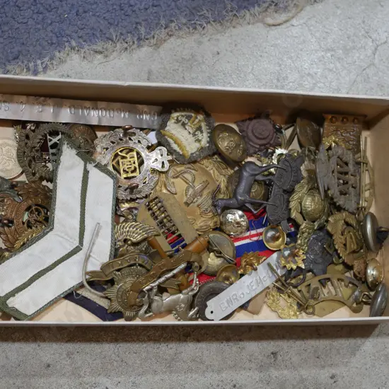 Assorted military badges, brass buttons etc