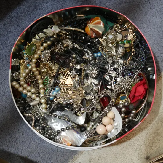 Tin of costume jewellery