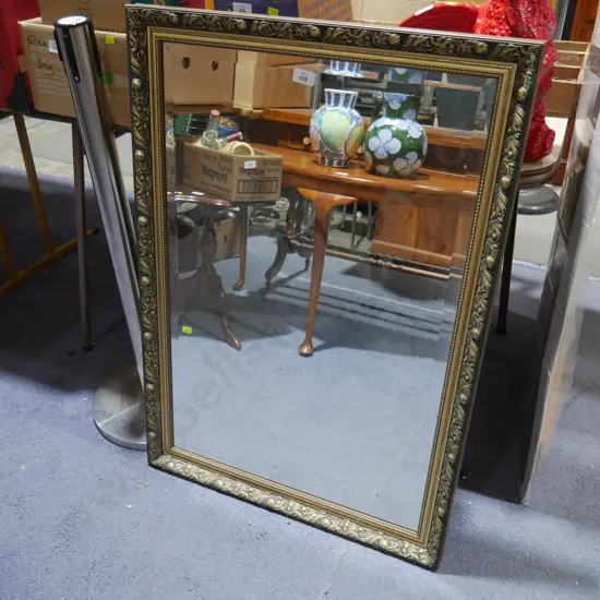 Black and gold framed mirror