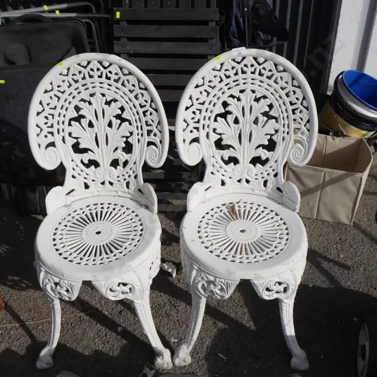 2 white wrought iron chairs
